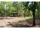 View of a wooded backyard, with trees offering privacy and a clear area for outdoor activities at 206 Pine Cedar Cir, Brooks, GA 30205