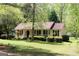 Inviting single-story home featuring a cozy front porch, American flag, and meticulously maintained landscaping at 206 Pine Cedar Cir, Brooks, GA 30205