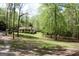 A glimpse of a charming home nestled in the woods, surrounded by lush greenery and tall trees at 206 Pine Cedar Cir, Brooks, GA 30205
