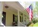 Charming front porch view showcasing classic architectural details and American flag at 206 Pine Cedar Cir, Brooks, GA 30205