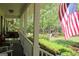 Inviting covered front porch with a swing, ample seating, and a view of the lush, landscaped front yard at 206 Pine Cedar Cir, Brooks, GA 30205