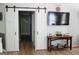 Hallway with sliding barn doors leading to hallway, wood floors, and decorative table with TV at 206 Pine Cedar Cir, Brooks, GA 30205