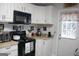 Inviting kitchen showcasing black appliances and white cabinets, with access to an outdoor space at 206 Pine Cedar Cir, Brooks, GA 30205