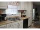 Charming kitchen featuring a stainless steel double sink, white cabinets and a black dishwasher at 206 Pine Cedar Cir, Brooks, GA 30205