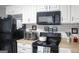 Cozy kitchen with black appliances, white cabinets, and subway tile backsplash at 206 Pine Cedar Cir, Brooks, GA 30205
