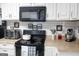 Well-equipped kitchen featuring black appliances and a stylish subway tile backsplash at 206 Pine Cedar Cir, Brooks, GA 30205