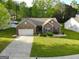 An elevated shot of a brick home with a manicured lawn and tree-lined streets at 327 Viceroy Curv, Stockbridge, GA 30281