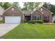 Charming brick home features a two-car garage and manicured front lawn with mature landscaping at 327 Viceroy Curv, Stockbridge, GA 30281