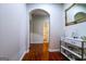 Hallway with hardwood floors, decorative table and framed art leading to arched doorway and bath at 327 Viceroy Curv, Stockbridge, GA 30281