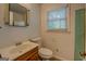Bathroom with a wood vanity, toilet, and window at 6950 Shannon Dr, Lithia Springs, GA 30122