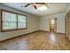Bedroom featuring wood-look flooring, ceiling fan, two windows, and en suite bathroom at 6950 Shannon Dr, Lithia Springs, GA 30122