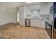 Bright kitchen features white cabinets, updated stainless steel appliances, and wood-look flooring at 6950 Shannon Dr, Lithia Springs, GA 30122