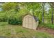A yellow storage shed sits amongst green grass and landscaping at 6950 Shannon Dr, Lithia Springs, GA 30122