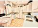 Bright kitchen with white cabinets, tile flooring, white appliances, and ample counter space at 144 Garden Walk, Stockbridge, GA 30281