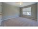 Bedroom with neutral walls, carpet flooring, a window, and a double-door closet at 20 Highgate Trl, Covington, GA 30016