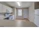 Bright kitchen featuring white cabinets, appliances, tile flooring, and access to the backyard at 20 Highgate Trl, Covington, GA 30016