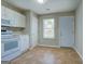 Bright kitchen featuring white appliances, tile flooring, and access to the backyard at 20 Highgate Trl, Covington, GA 30016