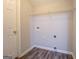 Empty laundry room with wood flooring, utility connections, and a wire rack shelf at 20 Highgate Trl, Covington, GA 30016