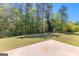 Expansive backyard featuring a concrete patio and lush lawn with mature trees at 202 Willow Rock Pt, Fayetteville, GA 30215