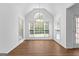 Bright dining room features vaulted ceiling, wood floors, large windows and modern chandelier at 202 Willow Rock Pt, Fayetteville, GA 30215