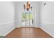A spacious dining room features hardwood floors, large window, and chandelier at 202 Willow Rock Pt, Fayetteville, GA 30215