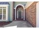 Close up of the front entrance features an arched doorway with white columns and an arched window, enhancing the home's curb appeal at 202 Willow Rock Pt, Fayetteville, GA 30215