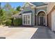 The elegant entryway features an arched doorway with decorative brickwork, flanked by white columns, adding charm to the home's exterior at 202 Willow Rock Pt, Fayetteville, GA 30215