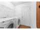 Well-equipped laundry room features washer, dryer, storage shelves and wood-look floors at 202 Willow Rock Pt, Fayetteville, GA 30215