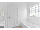 Bright bathroom boasts a large soaking tub, white cabinets, and a separate window at 202 Willow Rock Pt, Fayetteville, GA 30215