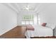 Bright main bedroom offers a tray ceiling, wood floors and large window for natural light at 202 Willow Rock Pt, Fayetteville, GA 30215