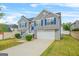 Well-manicured home with gray siding, white trim, blue shutters, and attached two car garage at 736 Mesa Rd, Mcdonough, GA 30253
