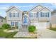 Charming two-story home with a well-manicured lawn, bright blue door and shutters, and a two-car garage at 736 Mesa Rd, Mcdonough, GA 30253