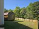 Spacious backyard showcases a wooden shed, lush greenery, and a newly installed fence at 1055 Field View Dr, Mcdonough, GA 30253