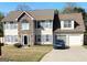 Inviting two-story home with a stone facade, blue shutters, well-manicured lawn, and attached garage at 1055 Field View Dr, Mcdonough, GA 30253