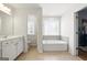 Bright and airy bathroom featuring large tub, single sink vanity, and tile flooring at 340 Hammersmith Dr, Suwanee, GA 30024