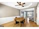 Dining room area with hardwood floors, a ceiling fan, wainscoting, and a view into the living room at 340 Hammersmith Dr, Suwanee, GA 30024