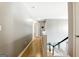 Upstairs hallway with hardwood floors, fresh neutral paint, and staircase with craftsman railings at 340 Hammersmith Dr, Suwanee, GA 30024