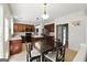 Spacious kitchen with dark wood cabinets, stainless steel appliances, and large island and adjacent dining area at 340 Hammersmith Dr, Suwanee, GA 30024