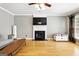 Comfortable living room with hardwood floors, fireplace with TV, and natural light at 340 Hammersmith Dr, Suwanee, GA 30024