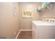 Efficient laundry room with a washer, dryer, shelving, and USA artwork in a neutral color palette at 11 Line Creek Cir, Sharpsburg, GA 30277