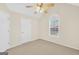 Cozy bedroom features a ceiling fan, neutral carpet and paint, and a window at 1313 Jubilee Ln, Mcdonough, GA 30253