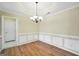 Elegant dining room featuring hardwood floors, chair rail molding and a stylish chandelier at 1313 Jubilee Ln, Mcdonough, GA 30253