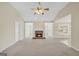 Spacious living room with a brick fireplace, neutral carpeting, and abundant natural light at 1313 Jubilee Ln, Mcdonough, GA 30253