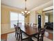 Elegant dining room with a decorative chandelier, a large window, and hardwood flooring at 3541 Stoneleigh Walk, Lithonia, GA 30038