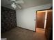 Bedroom featuring neutral carpet, printed wallpaper accent wall, ceiling fan, and closet at 1499 Carriage Ln, Jonesboro, GA 30238