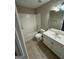 Neutral bathroom featuring a tiled shower over the tub, toilet, and vanity with a mirror at 135 Danube Trl, Stockbridge, GA 30281