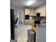 Bright kitchen with light wooden cabinets, granite countertops, and a black appliance package at 135 Danube Trl, Stockbridge, GA 30281