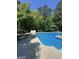 Bright and inviting pool area surrounded by a spacious patio and mature trees, perfect for summer fun and relaxation at 135 Danube Trl, Stockbridge, GA 30281