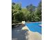 Inviting pool with clear blue water and lush greenery, offering a private and refreshing outdoor oasis at 135 Danube Trl, Stockbridge, GA 30281