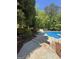 Scenic view of a sparkling pool with lush landscaping, mature trees, and a tranquil setting for relaxation at 135 Danube Trl, Stockbridge, GA 30281